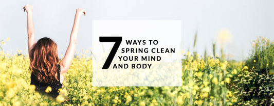 A promotional banner featuring a woman seen from behind with her arms raised in a vibrant yellow wildflower field, with text that reads "7 Ways to Spring Clean Your Mind and Body.